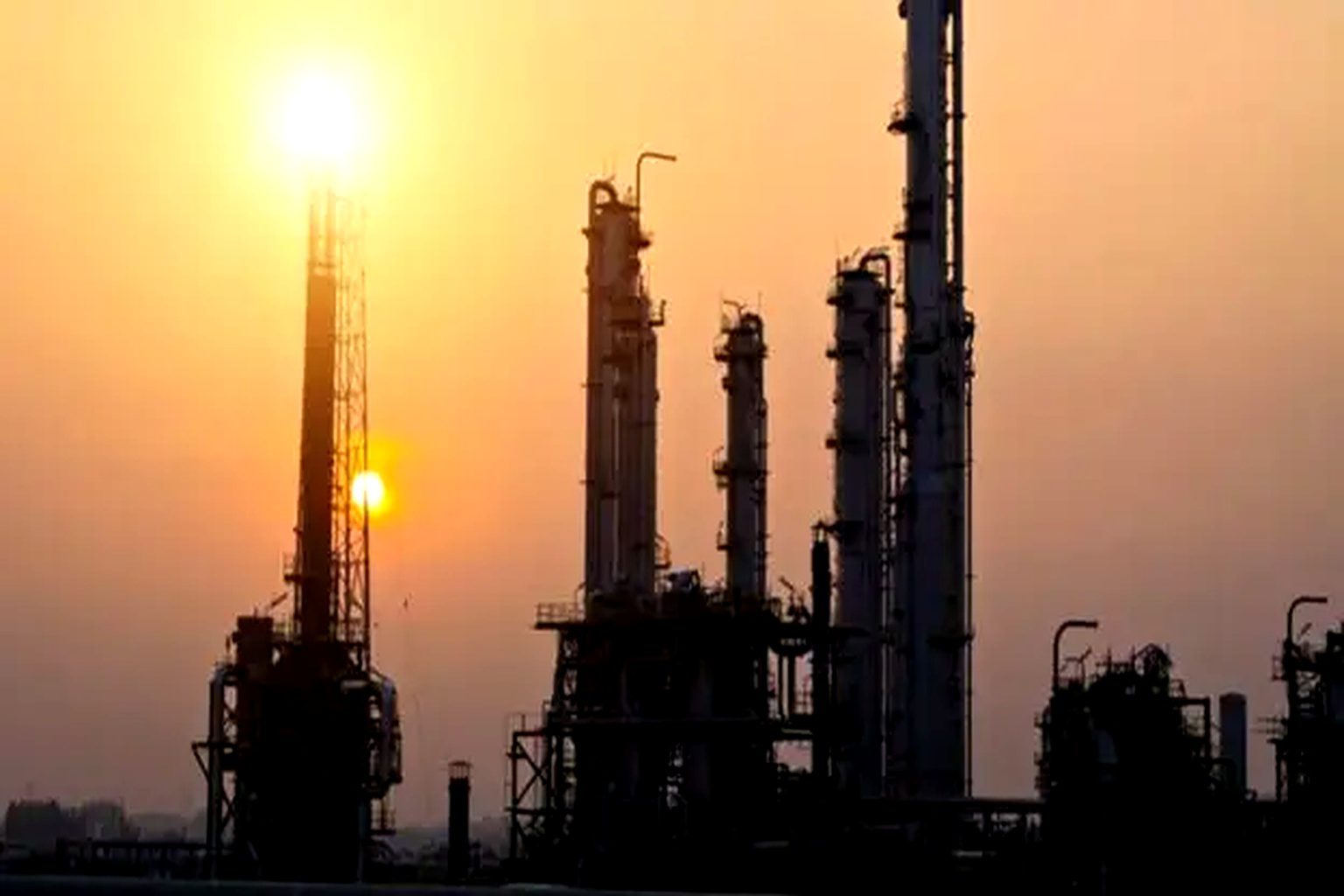 Oil & gas plant towers at sunset