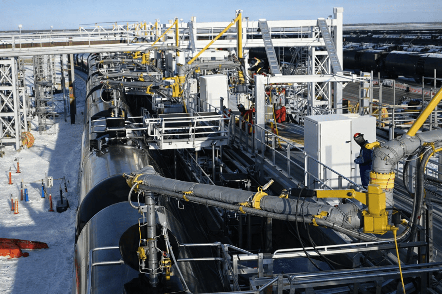 Energy tank battery facility with piping and processing equipment